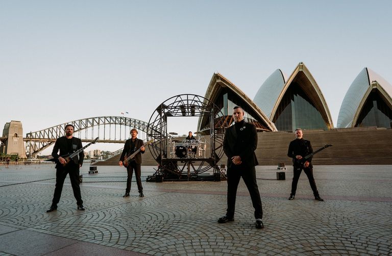 Australian metalcore band Parkway Drive posing in black suits in front of the Sydney Opera House and Harbour Bridge